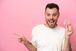 Mann zeigt seine Zahnschiene und verweist auf das Fazit